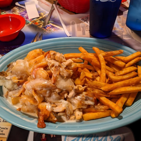 Cazadores Mexican Restaurant's creamy chicken and shrimp dish with a side of golden french fries.